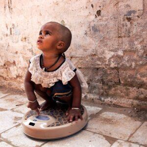 A child being weighed in Janta Colony.