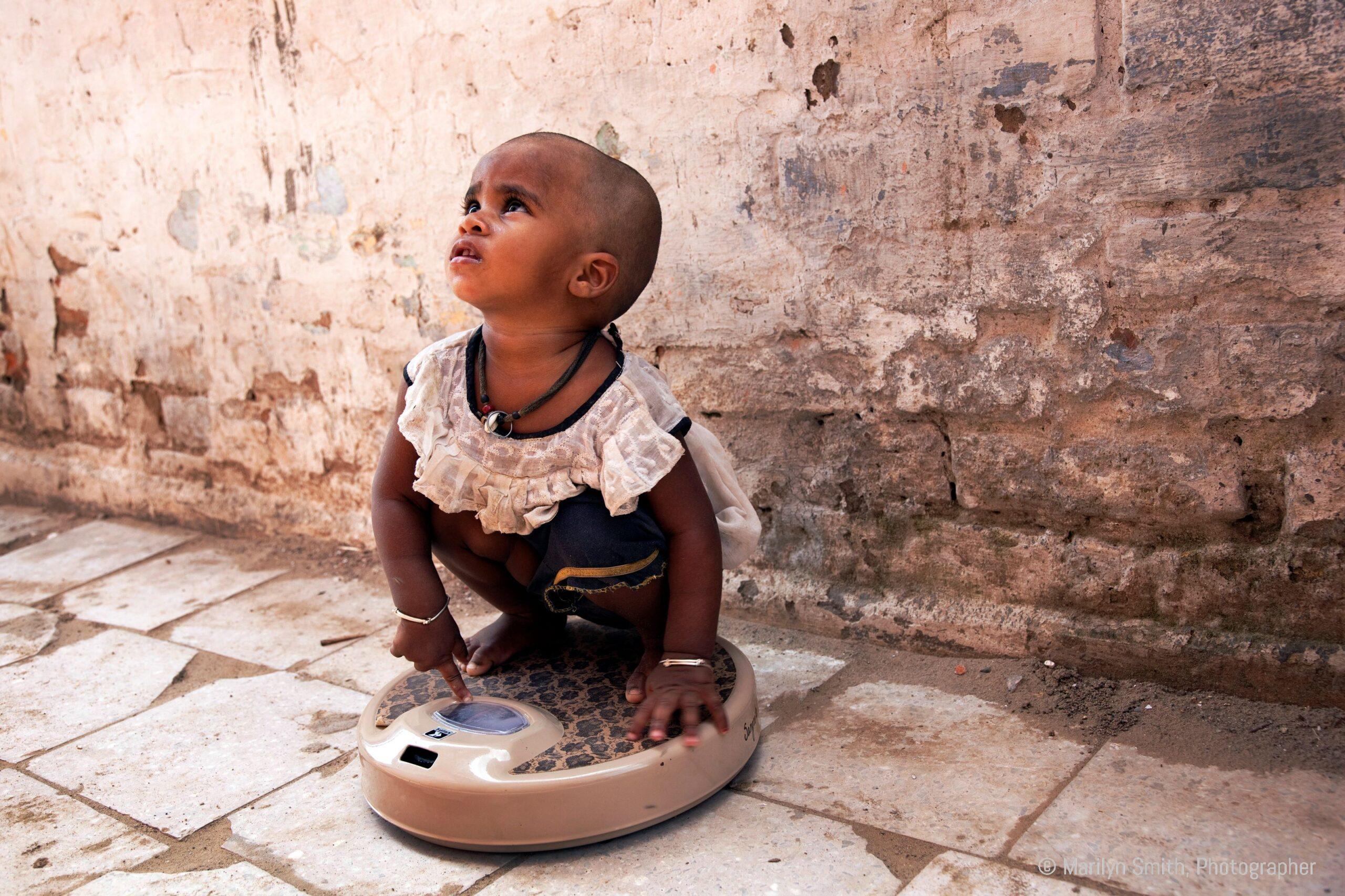 A child being weighed in Janta Colony.
