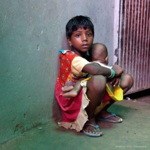 A young girl taking care of younger siblings.