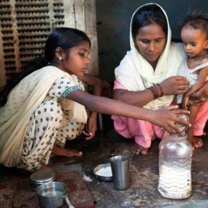 Ruby teaches the mother of Jyoti to make an oral rehydration solution.
