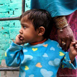 A young girl holds her grandmother's hand.