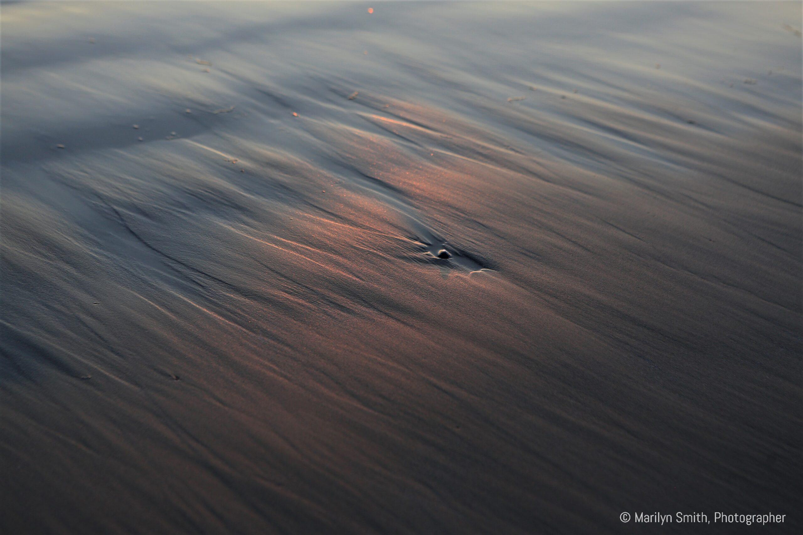 Sunset throwing a red reflection on Chesterman Beach, BC, Canada.