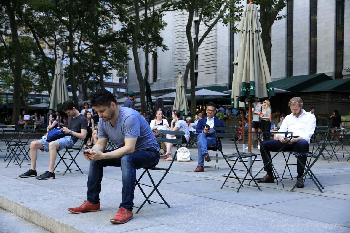 Bryant Park, New York City, people in close proximity, but alone on their cell phones.